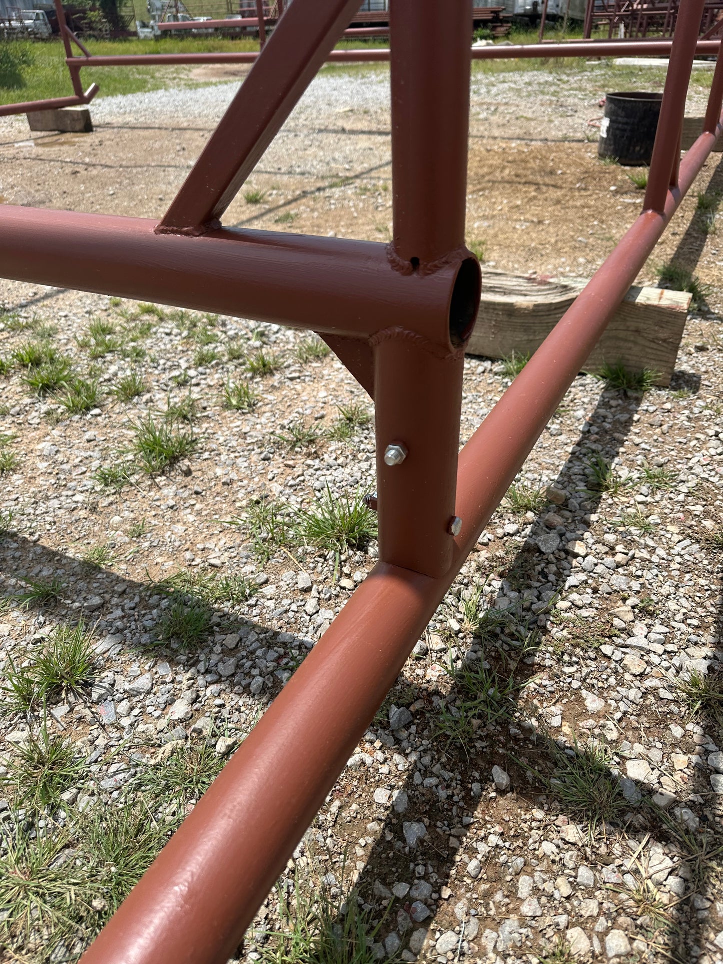 Close-up of a red metal pipe on a gravel ground